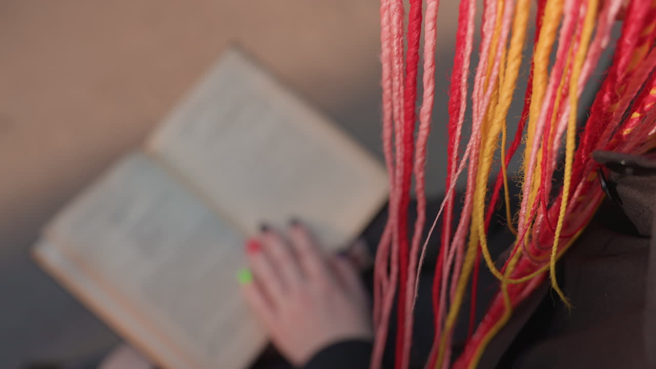 fotografía artística detallada, primer plano de un libro trenzado vibrante, toma íntima con coloridas páginas trenzadas e hilo, imagen enfocada de una mano hojeando un libro vintage decorativo