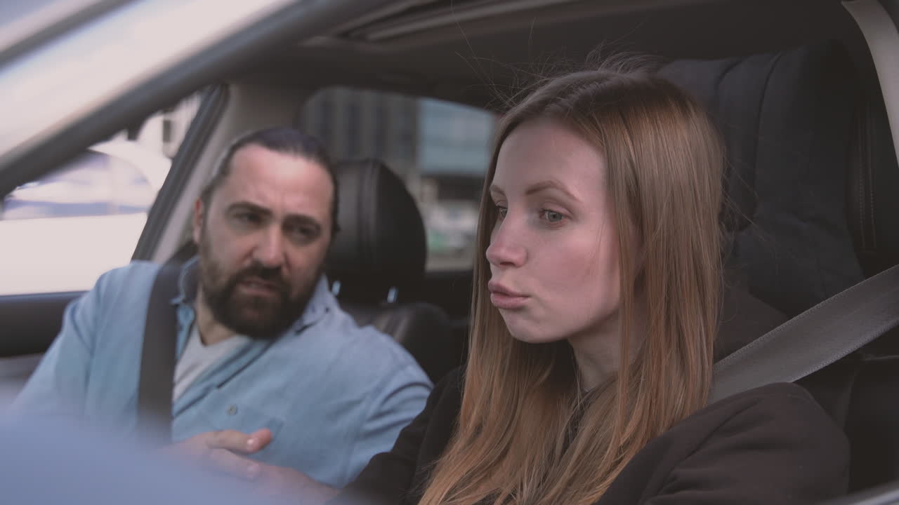 pareja discutiendo acaloradamente dentro de un auto mientras ella conduce 1