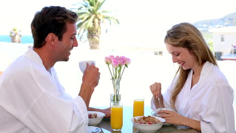 una pareja feliz desayunando juntos.