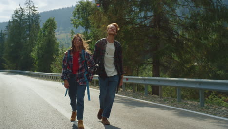 los caminantes felices disfrutan de hacer autostop en las montañas de verano.