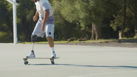 active middle-aged guy with leg prosthesis skateboarding