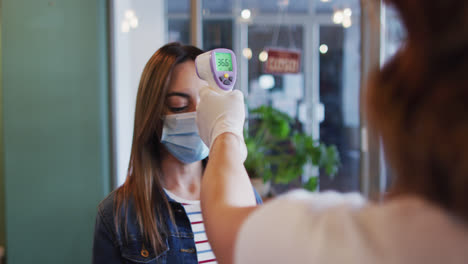 Mujer-Con-Mascarilla-Midiendo-Su-Temperatura-En-Una-Peluquería