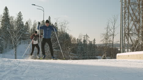 two people cross-country skiing on a snowy trail