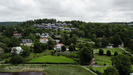 Deciduous-forest-covers-surrounding-homes-in-Ljungskile-Bohuslan-Sweden,-Aerial