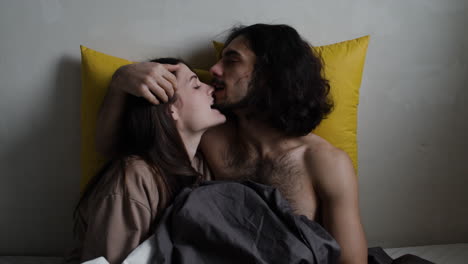 joven y mujer en la cama