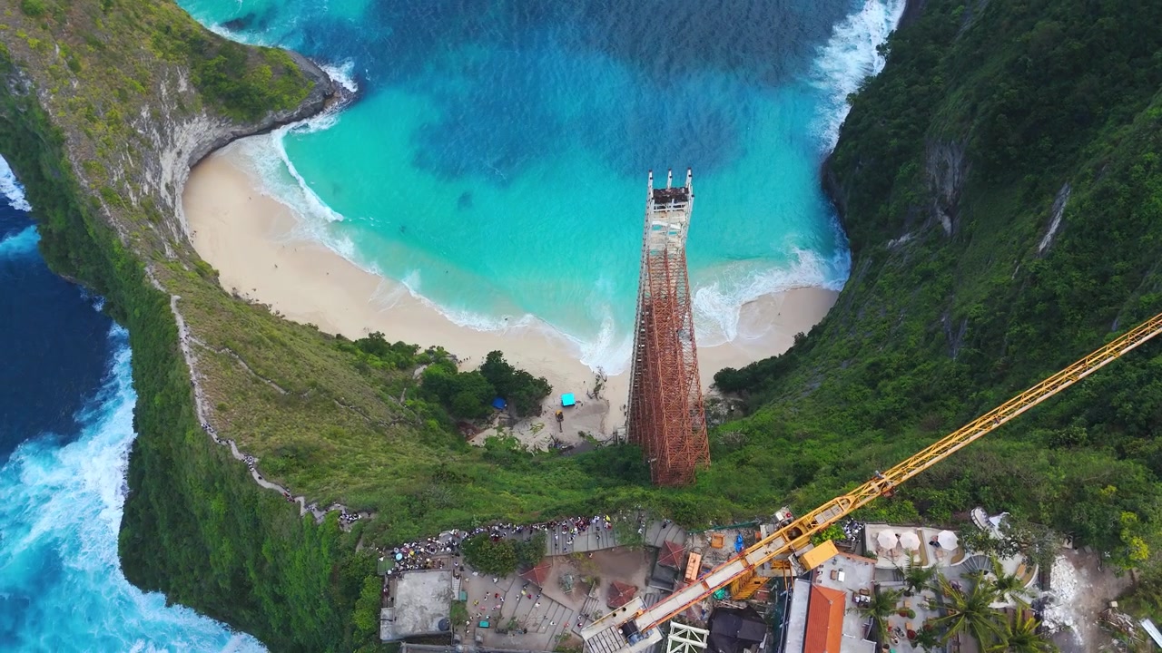 Konstruksi lift kaca yang diperintahkan untuk dibongkar karena masalah kepatuhan hukum, menghadap tebing T-Rex yang ikonik di Pantai Kelingking, Nusa Penida, Indonesia, tampilan dari atas