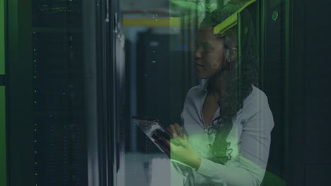 woman using tablet in server room with digital data processing animation overlay