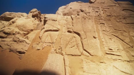 kings and hieroglyphs carved into rock outside of the karnak temple, in luxor egypt.slow camera movement.