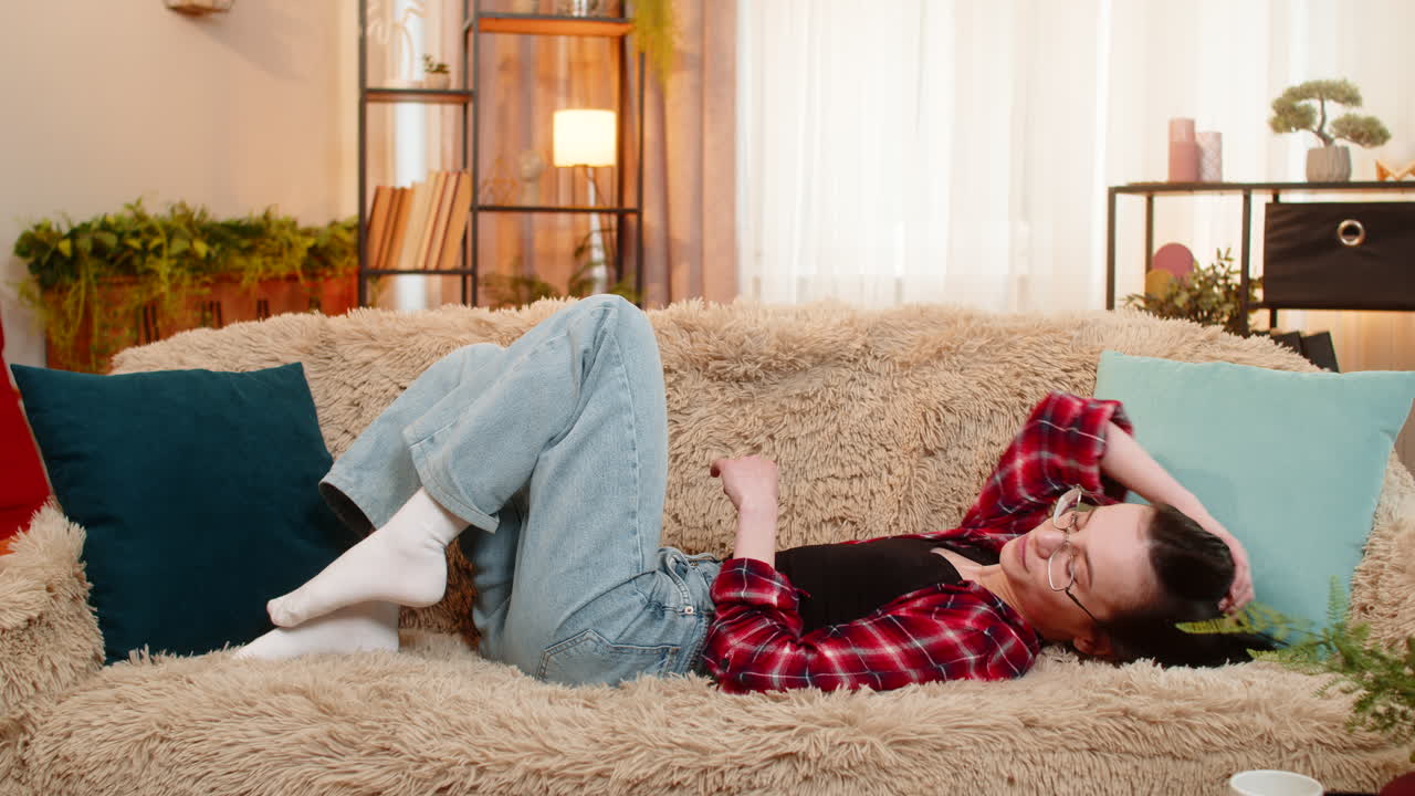 Happy woman arranging decorative pillows at home satisfaction while admiring clean living space
