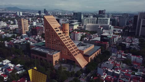 orbital shot of el palacio de hierro triangular shape store in polanco, mexico city in a cloudy sunday