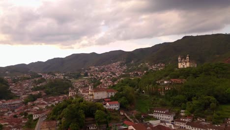 aerial drone push-in shot showcasing the entire colonial city of ouro preto, minas gerais, brazil, with nature blending into the white buildings