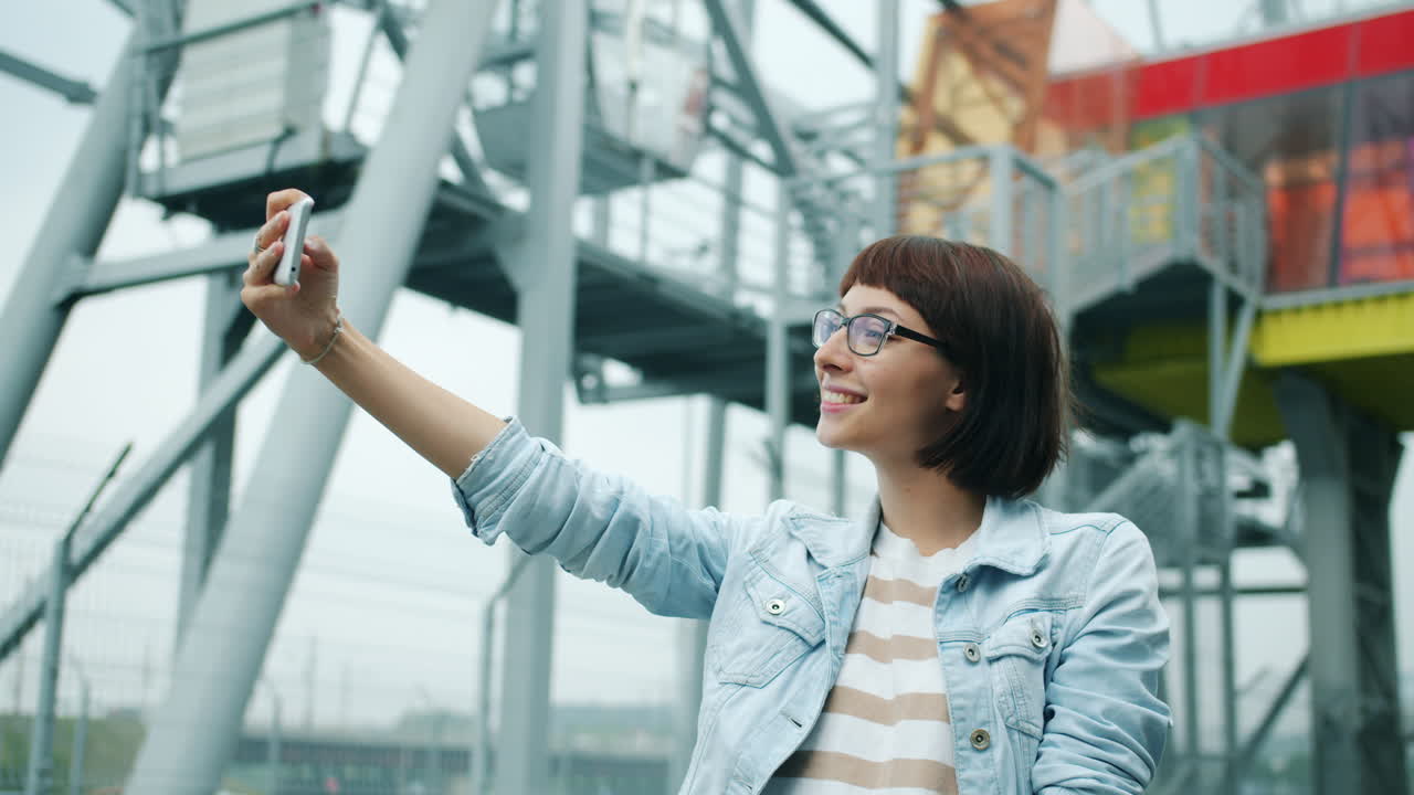 Donna che scatta selfie e fa videochiamate in un parco divertimenti