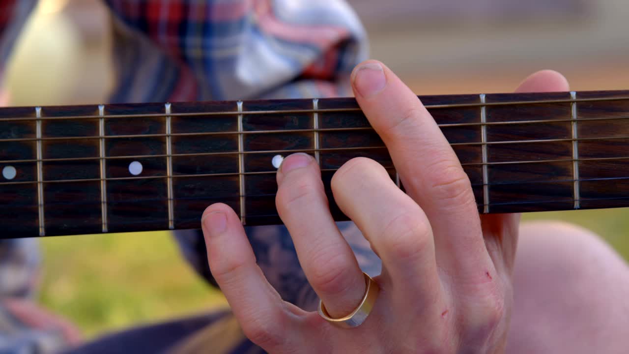 hombre tocando la guitarra en el jardín 4k