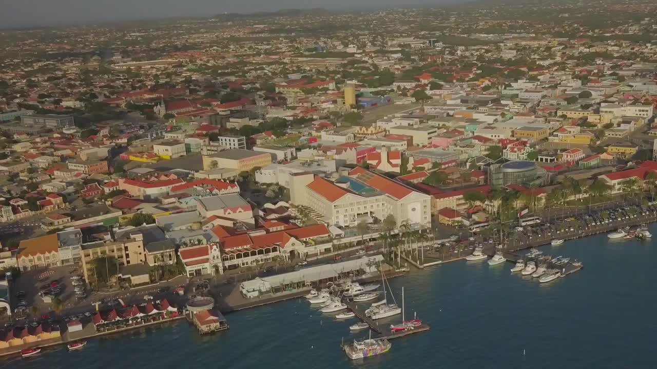 Aerial overview of the water and ships in the marina and cars on the busy street
