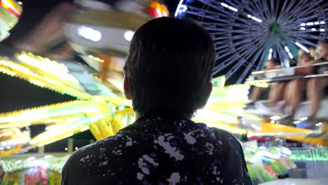 a young boy watches the rides at an