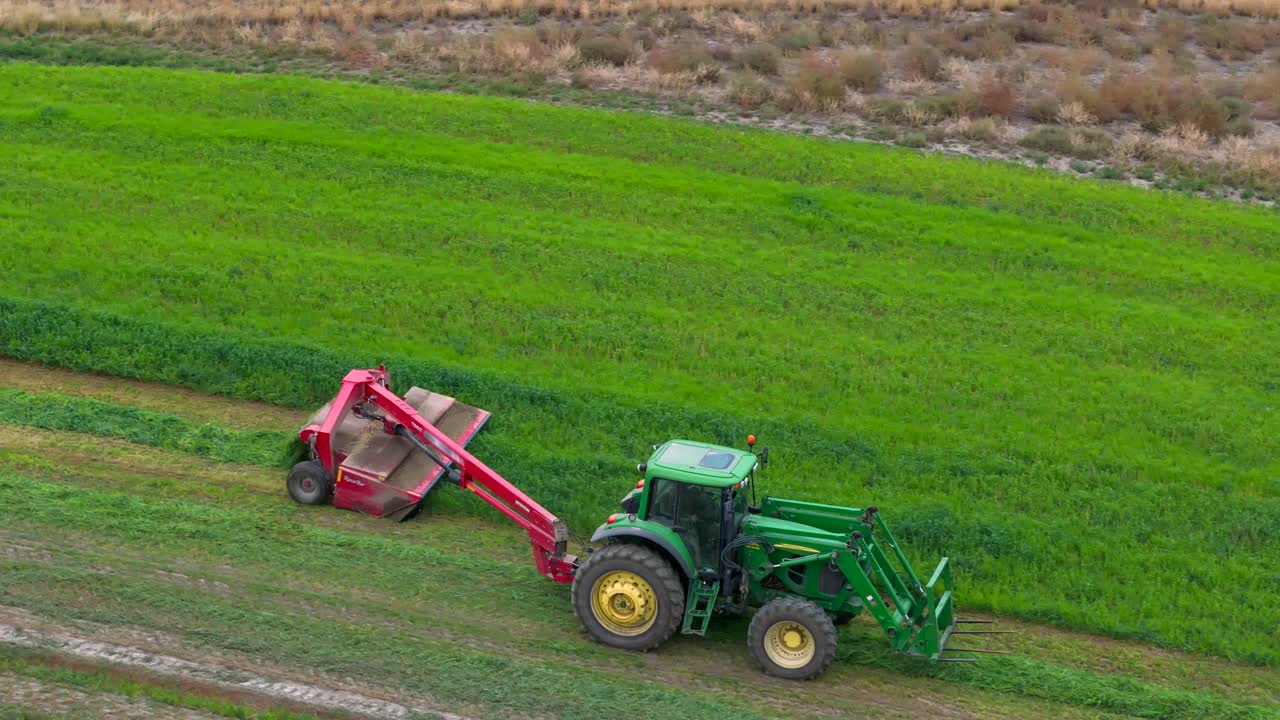 Circles of Abundance: A Bird's-Eye Scene of a Green Tractor Mowing Hay in British Columbia