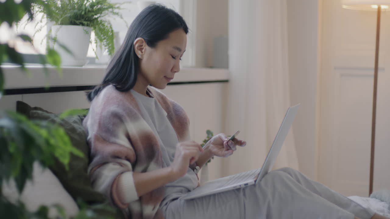 Woman Shopping Online on Laptop in Bedroom