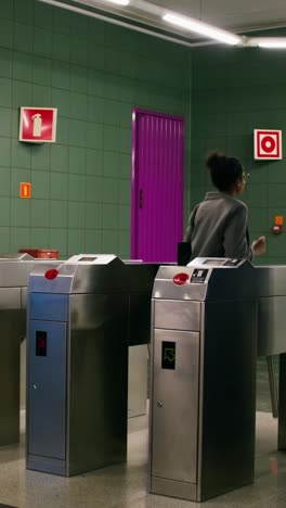 woman using turnstile at a subway station