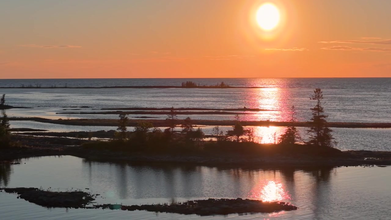 Klar nedgående sol reflekteres over Lake Huron bag beskyttede bassiner og lave Tobermory-øer