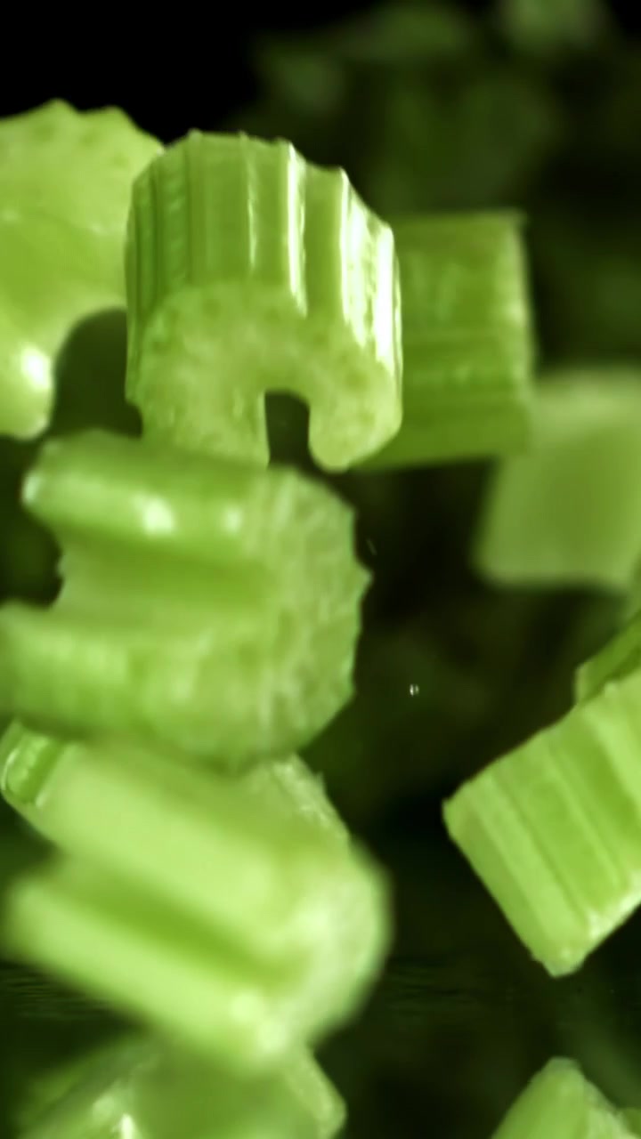 Chopped Green Celery Pieces Falling in Slow Motion