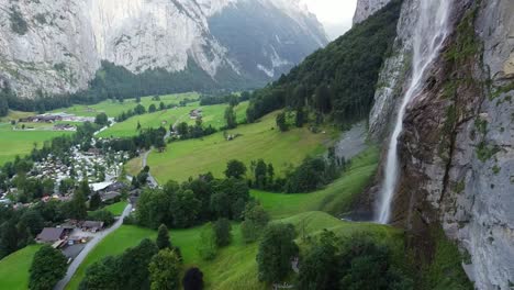 Paisaje-Urbano-De-Lauterbrunnen-Y-Vista-Aérea-De-Drones-En-Cascada-Sobre-Las-Montañas-Suizas-En-Los-Alpes