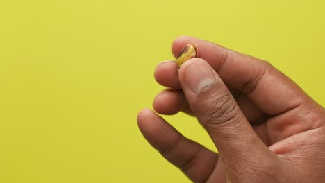 close-up of a hand peeling a pistachio nut