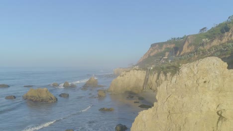 Tomas-Aéreas-De-La-Playa-El-Matador-Sobre-Olas-Y-Rocas-En-Una-Brumosa-Mañana-De-Verano-En-Malibu,-California