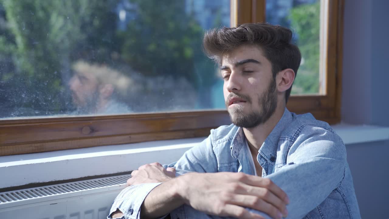 el hombre enfermo mira por la ventana para relajarse.