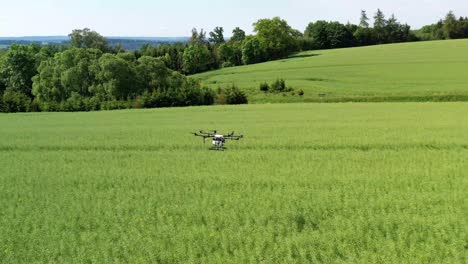Drone-Watering-an-Agriculture-Field,-Technology-Aerial-Pan-Tracking-Shot