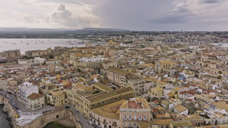 siracusa, italia, sobrevuelo aéreo v1 cinematográfico y alrededor de la isla de ortigia capturando una encantadora ciudad costera mediterránea con edificios arquitectónicos históricos de piedra - filmado con mavic 3 cine - junio 2023