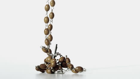 rosary beads falling onto a white surface