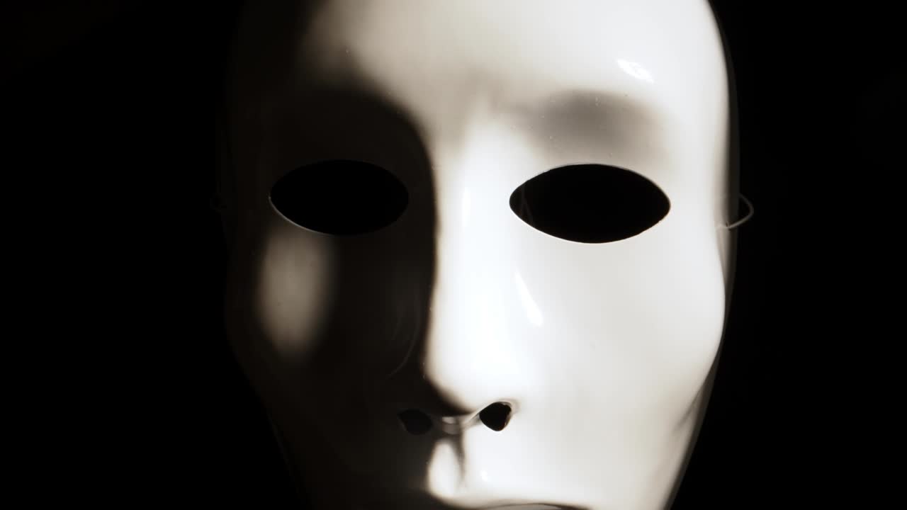 White face mask on dark background.