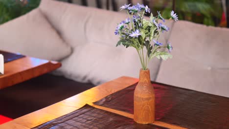 wooden vase with flowers on a restaurant table