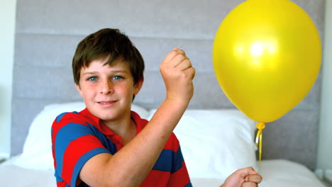 niño perforando su globo en el dormitorio