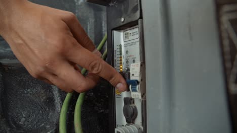 static close-up shot of a caucasian male tourist in africa as he checks if the fuses of his camping refrigerator is inserted correctly.