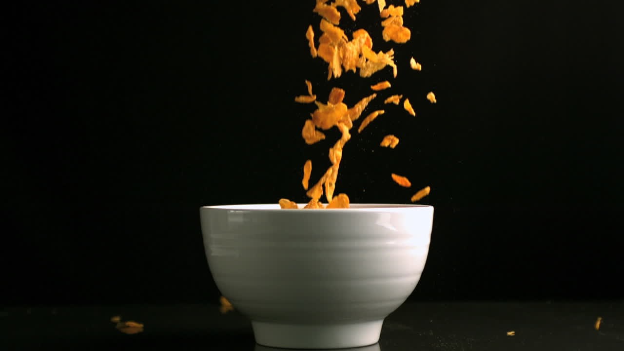 Cereali che cadono in una ciotola bianca