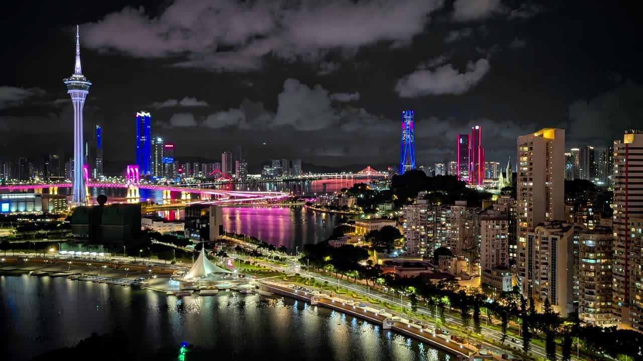 Cool-toned twilight view of Macau skyline from rooftop, city lights reflect in water