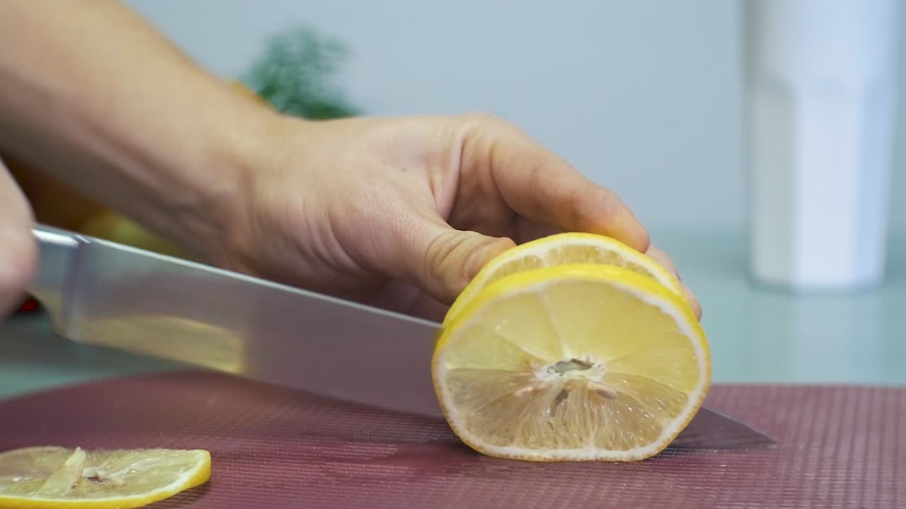 hombre cortando limón amarillo con un cuchillo en la tabla de cortar fondo blanco con frutas