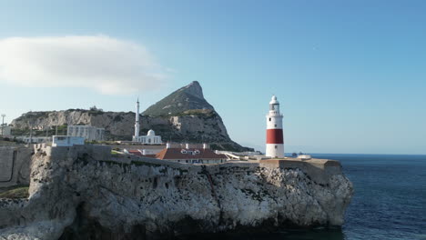 Un-Hermoso-Dron-En-órbita-Lenta-De-4k-Filmado-Alrededor-Del-Faro-De-Gibraltar-Al-Atardecer-Con-El-Peñón-De-Gibraltar-Al-Fondo