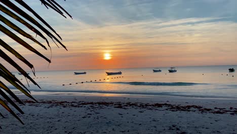 Boote-In-Der-Silhouette-Schwimmen-Auf-Dem-Meer-Bei-Sonnenaufgang-In-Tulum-Beach,-Mexiko