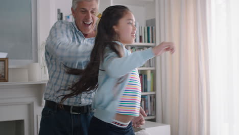 happy-little-girl-hugging-grandfather-playfully-jumping-into-grandad's-arms-having-fun-enjoying-weekend-with-grandparent-at-home