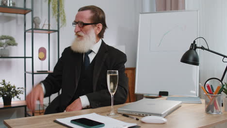 a senior businessman celebrating success with a glass of champagne