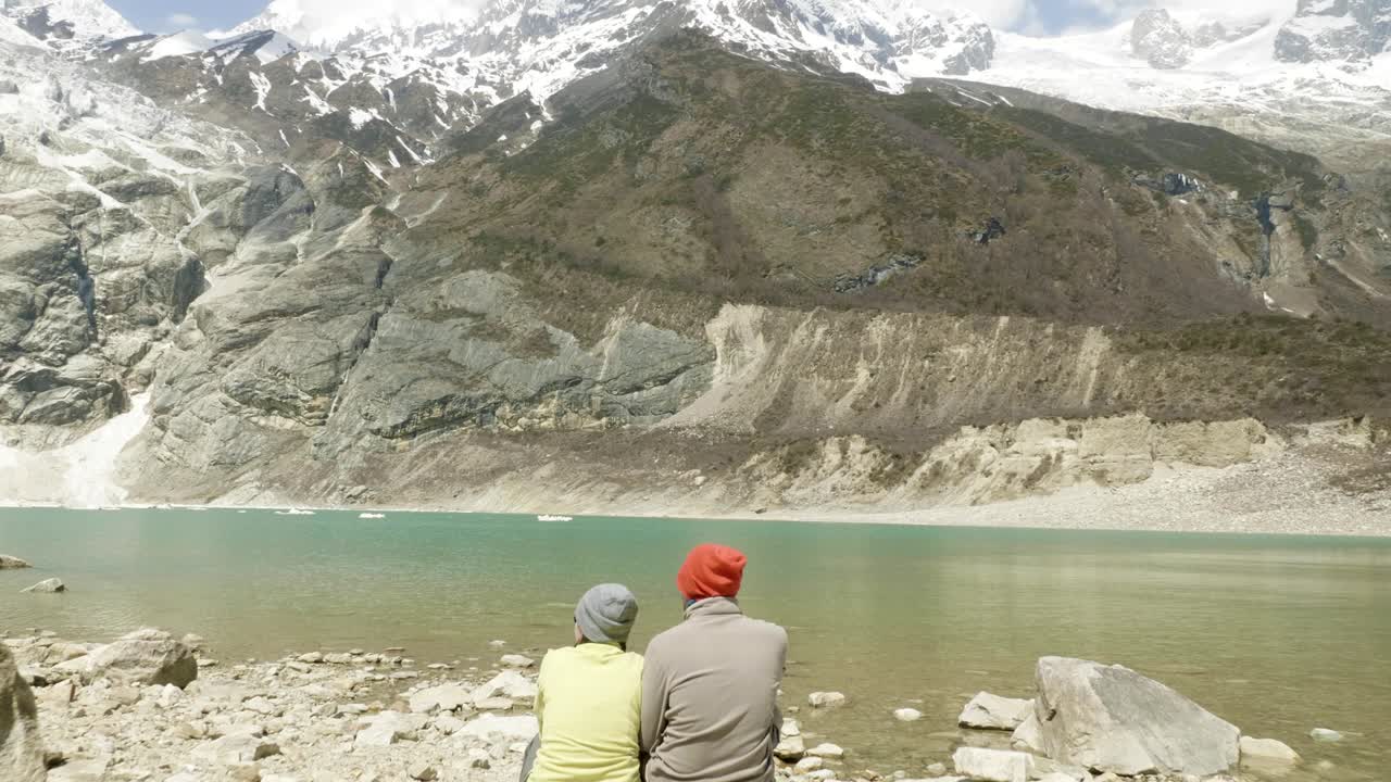 una pareja se sienta en el lago de montaña birendra en nepal. área de manaslu.
