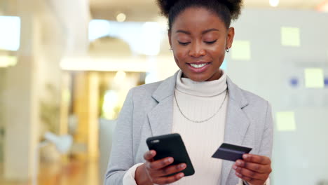 woman using a phone and bank card to make