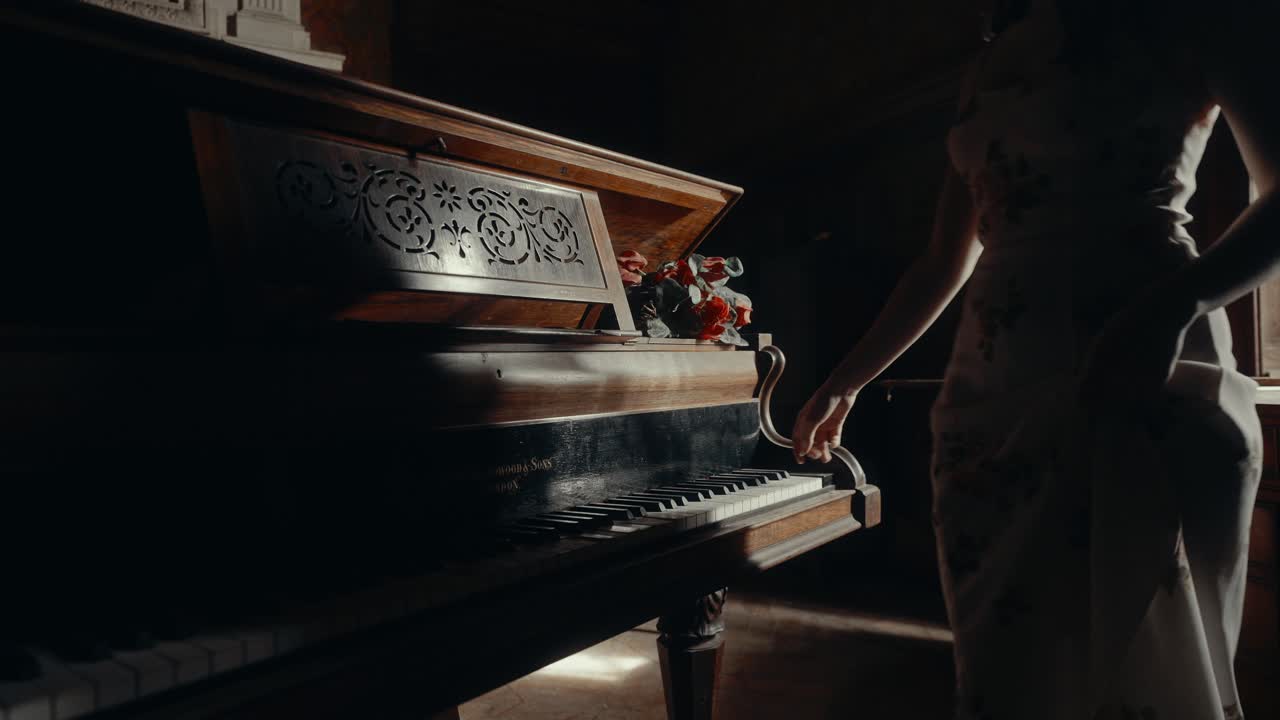 Woman's Hand Gently Touches Keys of an Old Vintage Piano