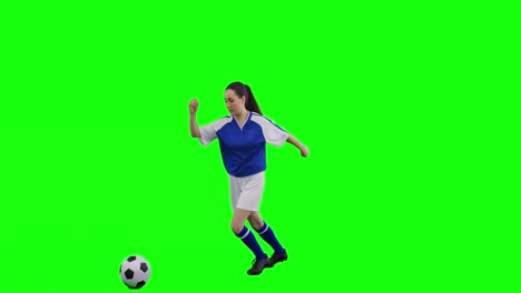 Video-of-caucasian-female-football-player-kicking-football-and-copy-space-on-green-screen