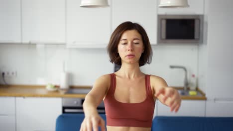 Frau-Verdreht-Ihre-Arme,-Praktiziert-Yoga-Zu-Hause,-Vorderansicht