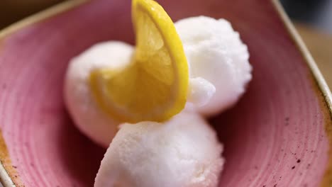 lemon ice cream scoops in a pink bowl