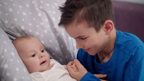 older brother kissing baby hand. adorable brothers love concept