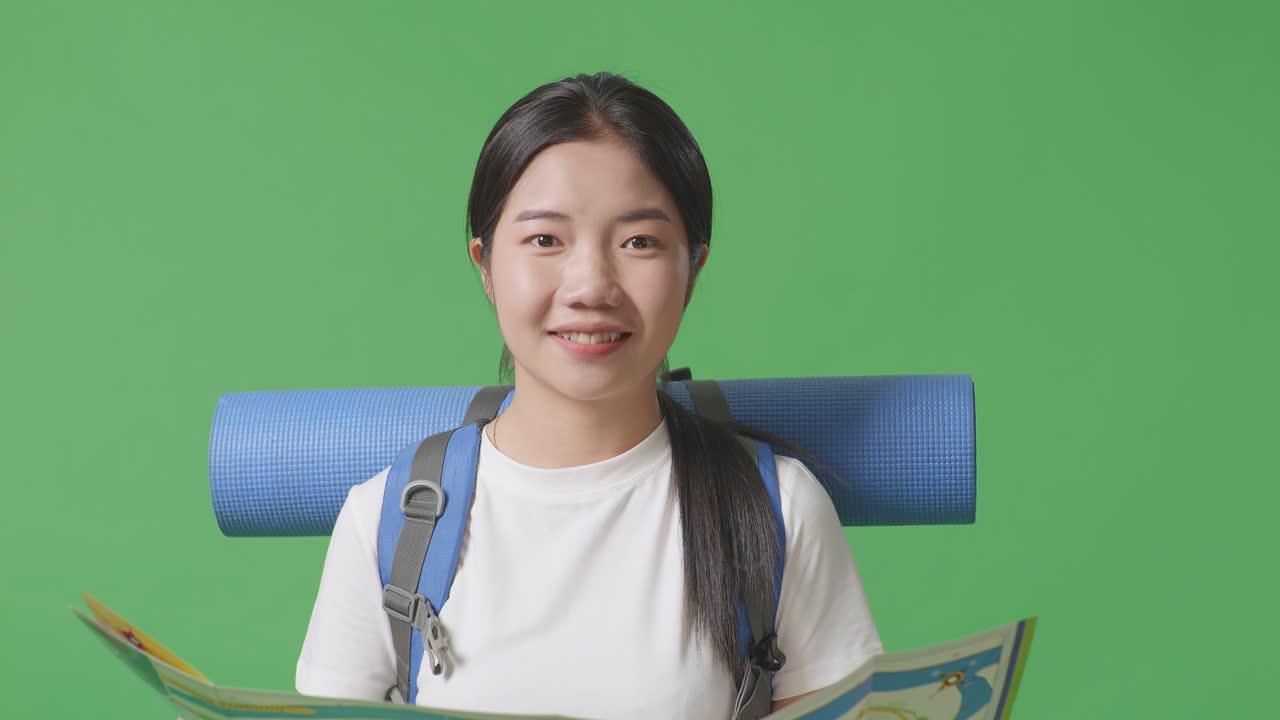 mujer mirando un mapa mientras sonríe